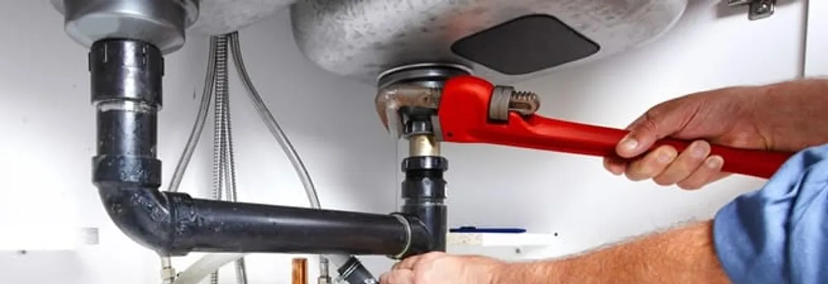 Garbage disposal repair technician tightening the sink drain and disposal connection in Lakewood, CO
