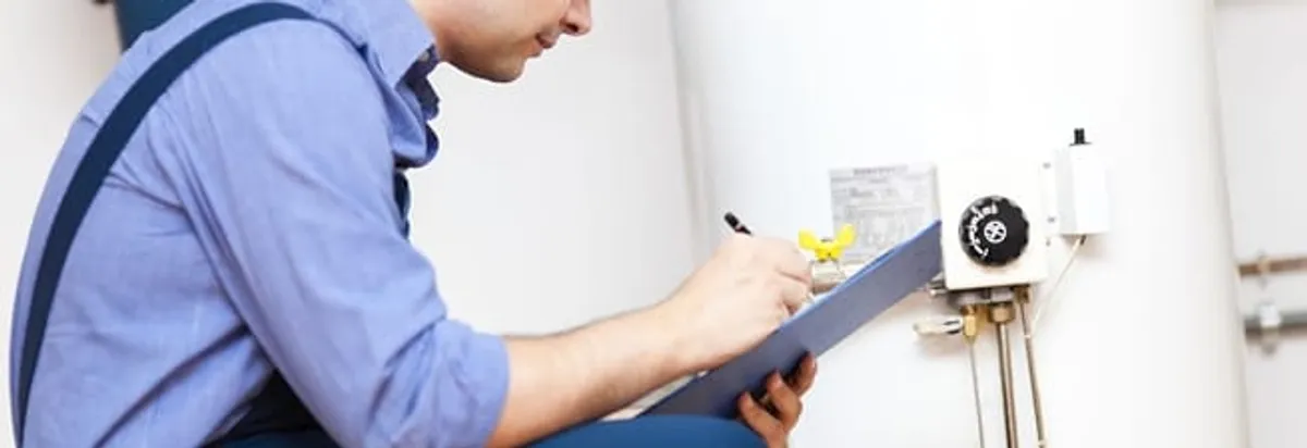 Water heater repair technician inspecting the unit and recording service notes in Lakewood, CO